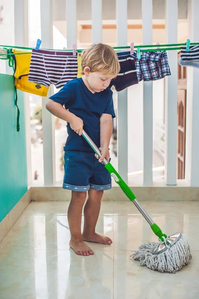 Pojken städar, tvättar golvet med mopp. Liten hemhjälp — Stockfoto