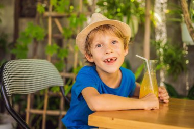 Kafede portakal suyu içen tatlı bir çocuk.