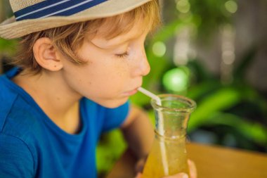 Kafede portakal suyu içen tatlı bir çocuk.