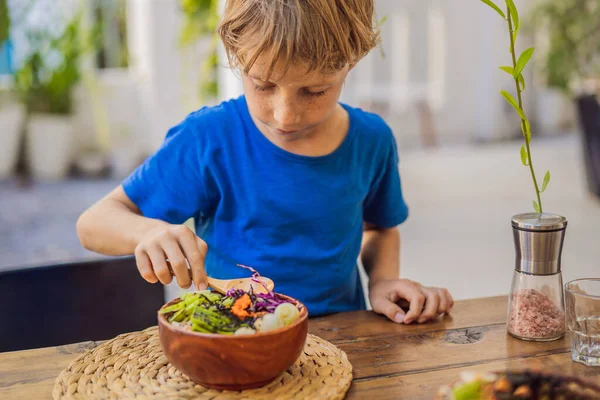 Boy eating Poke bowl with shrimp, corn, avocado, ginger and mushrooms — Stock Photo, Image