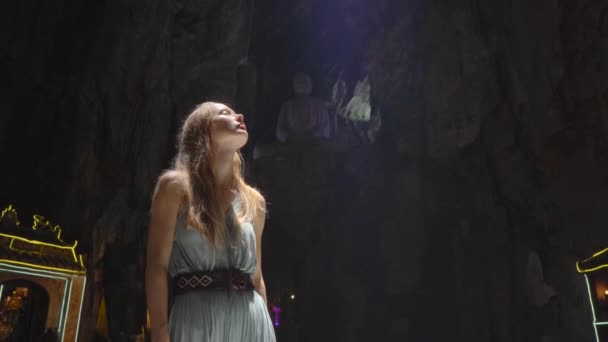 Uma jovem turista visita o maior templo caverna nas montanhas de mármore um complexo de templos budistas, um famoso destino turístico na cidade de Da Nang, no centro do Vietnã. Um feixe de luz solar — Vídeo de Stock