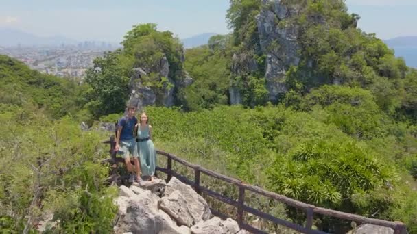 Un par de jóvenes turistas hacen una selfie de pie en la cima de las montañas de mármol en Da Nang. Viajar a Da Nang concepto — Vídeo de stock