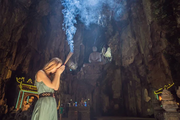 Jonge vrouw biddend in een Boeddhist tempel houdende wierook Huyen Khong Grot met heiligdommen, Marmeren bergen, Vietnam — Stockfoto
