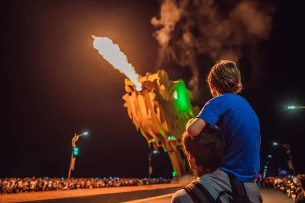 Dad and son watching dragon making fire on the Dragon Bridge, a famous bridge in Da Nang. Da Nang City is Famous city for visiting in Vietnam