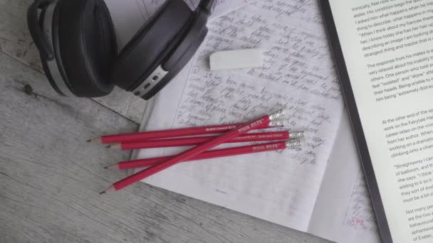 Sydney, Australia, 14.07.2020: Lápices rojos IELTS, lectura de texto y escucha de auriculares y cuaderno de ensayo para el examen de inglés — Vídeo de stock