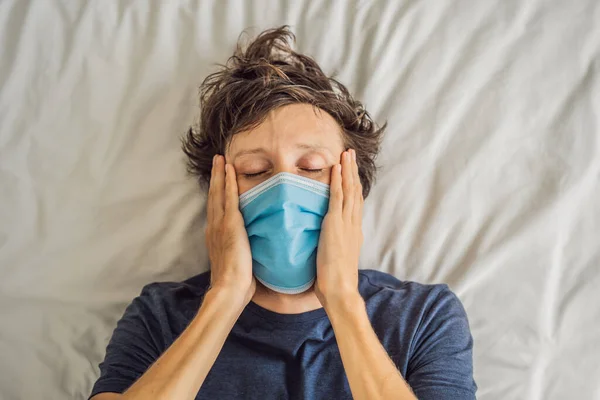 Extremly tired young man lying on the bed, home alone. self-isolation at home, quarantine due to pandemic COVID 19. Mental health problems in self-isolation at home — Stock Photo, Image