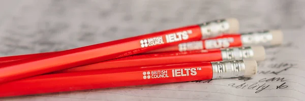 Vietnam, Nha Trang, 14.07.2020: IELTS red pencils and essay notebook for the English exam BANNER, long FORMAT — 스톡 사진