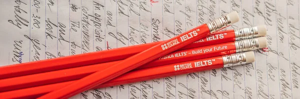 Vietnam, Nha Trang, 14.07.2020: IELTS red pencils and essay notebook for the English exam BANNER, long FORMAT — 스톡 사진