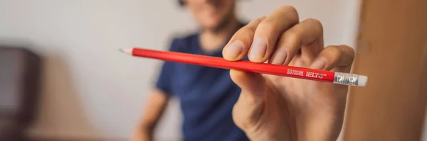 Vietnam, Nha Trang, 14.07.2020: A man prepares for the IELTS exam IELTS red pencils, reading text and listening headphones and essay notebook for the English exam BANNER, LONG FORMAT — Stock Photo, Image