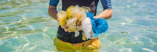 Człowiek zbiera paczki z pięknego turkusowego morza. Rajskie zanieczyszczenie plaży. Problem rozlane śmieci śmieci śmieci na piasku plaży spowodowane przez człowieka zanieczyszczenia i środowiska, kampania do — Zdjęcie stockowe