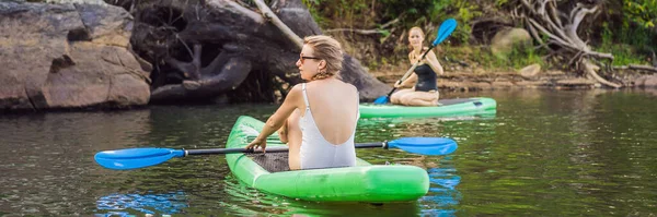 Seitenansicht einer Frau, die entspannt auf dem Sup Board sitzt. Surferin ruht sich aus, LANG FORMAT — Stockfoto