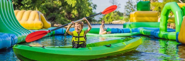Glad ung pojke som håller paddla i en kajak på floden, njuter av en härlig sommardag BANNER, LONG FORMAT — Stockfoto