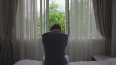 Zorunlu karantinada olan genç bir adam. Oturur ve pencereden dışarı bakar. İki hafta boyunca bir odada kalıyor. Uzun süre tıraş olmadı, stresli ve üzgün. Karantina konseptinde kalmak