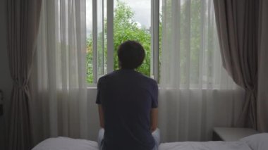 Zorunlu karantinada olan genç bir adam. Oturur ve pencereden dışarı bakar. İki hafta boyunca bir odada kalıyor. Uzun süre tıraş olmadı, stresli ve üzgün. Karantina konseptinde kalmak