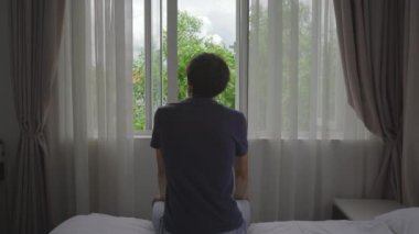 Zorunlu karantinada olan genç bir adam. Oturur ve pencereden dışarı bakar. İki hafta boyunca bir odada kalıyor. Uzun süre tıraş olmadı, stresli ve üzgün. Karantina konseptinde kalmak