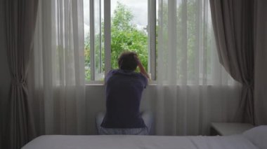 Zorunlu karantinada olan genç bir adam. Oturur ve pencereden dışarı bakar. İki hafta boyunca bir odada kalıyor. Uzun süre tıraş olmadı, stresli ve üzgün. Karantina konseptinde kalmak
