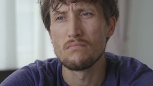 Closeup shot of a young man in mandatory quarantine. He stays in one room for two weeks. He did not shave for a long time, he is stressed and upset. Staying in quarantine concept. Concept of the — Stock Video