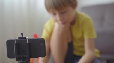 Küçük bir çocuk akıllı telefon kullanarak arkadaşları ve akrabalarıyla oyun oynuyor ve konuşuyor. Covid-19 tehlikesi yüzünden karantinada kalıyor. COVID 'nin ikinci dalgası kavramı