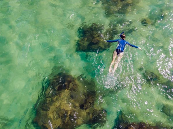 Die Frau schnorchelt zwischen den Korallen. Blick von der Drohne — Stockfoto