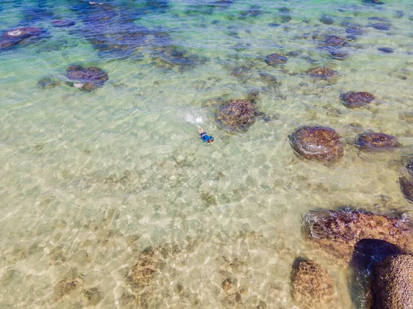 O rapaz está a mergulhar entre os corais. Vista do drone — Fotografia de Stock