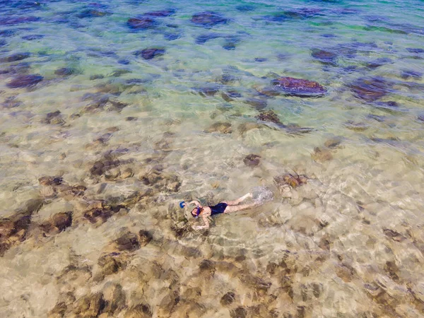 La femme est en train de plonger parmi les coraux. Vue depuis le drone — Photo