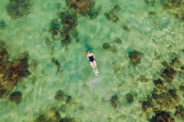 La femme est en train de plonger parmi les coraux. Vue depuis le drone — Photo