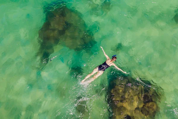 Die Frau schnorchelt zwischen den Korallen. Blick von der Drohne — Stockfoto