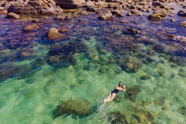 La femme est en train de plonger parmi les coraux. Vue depuis le drone — Photo