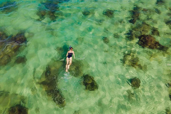 La femme est en train de plonger parmi les coraux. Vue depuis le drone — Photo