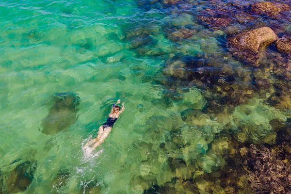 La femme est en train de plonger parmi les coraux. Vue depuis le drone — Photo