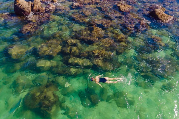 La femme est en train de plonger parmi les coraux. Vue depuis le drone — Photo