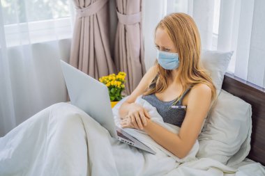 Kadın yatakta yatıyor ve pratisyen hekimle online istişare yapıyor.