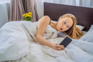 Alarmı duymayıp geç uyanan kadının telefonuna bakarken yüzünde şaşkın bir ifade vardı.