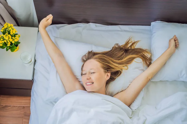 Νεαρή γυναίκα ξυπνάει ευτυχισμένη, μετά από έναν καλό ύπνο. — Φωτογραφία Αρχείου