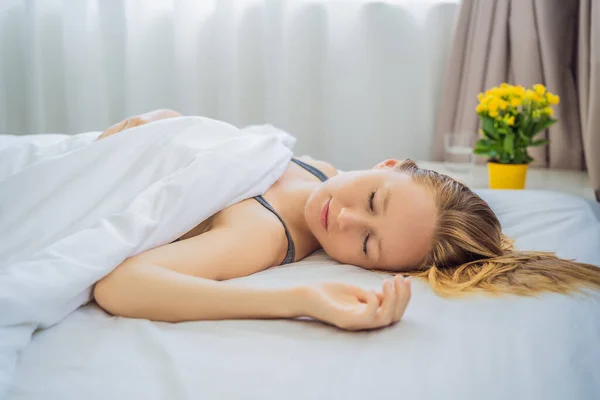 Κοιμήσου χωρίς μαξιλάρι. Νεαρή γυναίκα κοιμάται στο κρεβάτι χωρίς μαξιλάρι. Πορτρέτο της όμορφης γυναίκας αναπαύεται σε άνετο κρεβάτι χωρίς μαξιλάρι σε λευκό κρεβάτι σε ελαφρύ υπνοδωμάτιο το πρωί. Άνθρωποι — Φωτογραφία Αρχείου