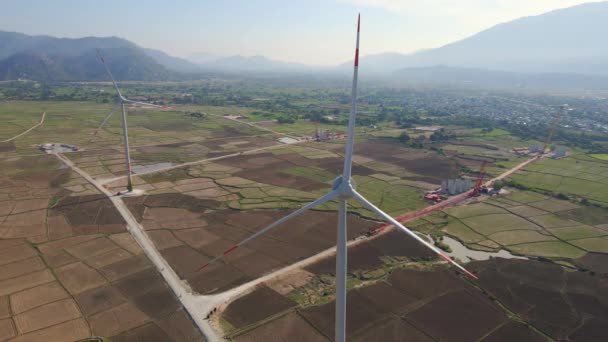 Tiro aéreo de um complexo de turbinas eólicas em pé em um grande campo agrícola. Conceito de energia verde. Conceito de emissões zero — Vídeo de Stock