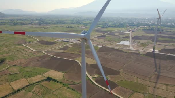 Aerial shot of a complex of wind turbines standing on a big farming field. Green energy concept. Zero emissions concept — Stock Video