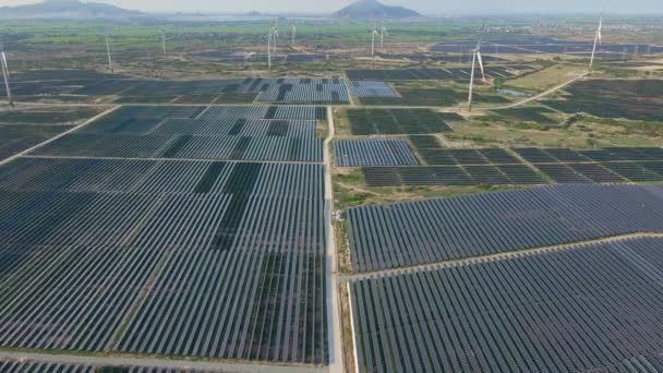 Toma aérea de una enorme planta de energía solar en un gran campo. Generación de electricidad a partir de energía solar. Energía verde y concepto de cero emisiones — Vídeos de Stock