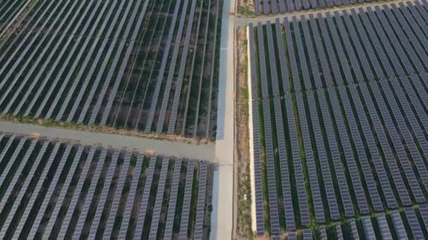 Légi felvétel egy hatalmas naperőműről egy nagy mezőn. Villamosenergia-termelés napenergiából. Zöld energia és kibocsátásmentes koncepció — Stock videók