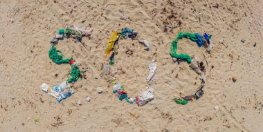 Çevresel bir sorun. Ekoloji konsepti. Plastik plajda yazılar var. Sahile çöp döktüm.