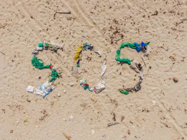 Çevresel bir sorun. Ekoloji konsepti. Plastik plajda yazılar var. Sahile çöp döktüm.