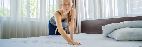 若い女性の家政婦がホテルの部屋でベッドを変える｜バナー、ロングフォーマット — ストック写真