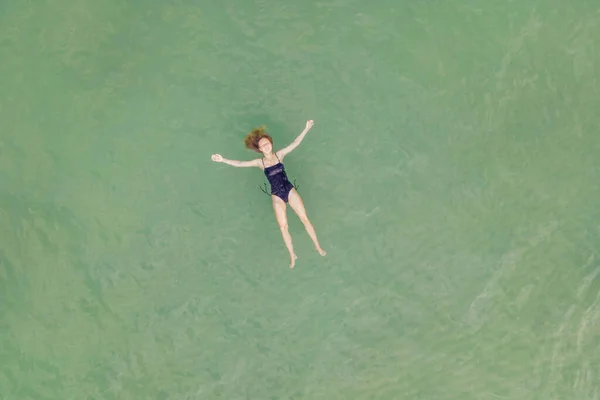 Mam en zoon in helder turquoise water op het strand. Drone aanzicht — Stockfoto