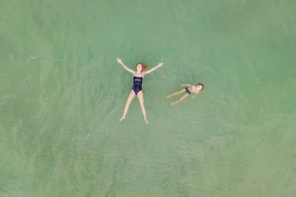 Maman et son fils dans l'eau turquoise claire sur la plage. Vue sur drone — Photo