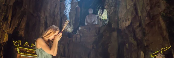 Mujer joven rezando en un templo budista sosteniendo incienso Cueva Huyen Khong con santuarios, montañas de mármol, Vietnam BANNER, FORMATO LARGO — Foto de Stock