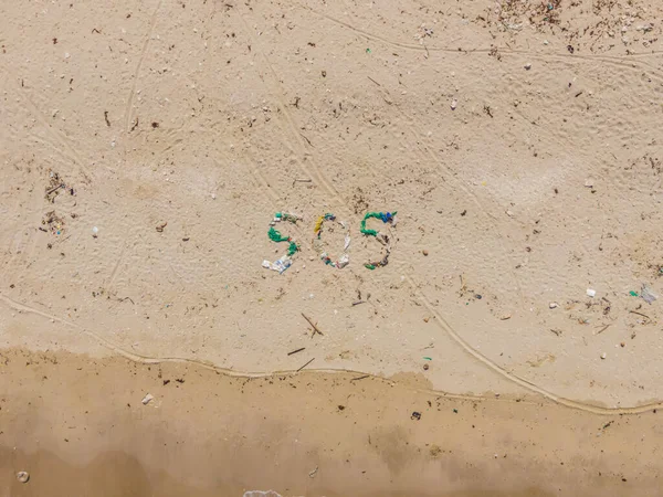 Umweltproblem. Ökologiekonzept. Plastik am Strand mit einem Schriftzug. Verschütteter Müll am Strand — Stockfoto