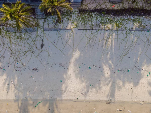 Піщаний пляж з пластиковим сміттям і медичними відходами на тропічному пляжі зі смарагдовим видом, зробленим безпілотним літаком. — стокове фото