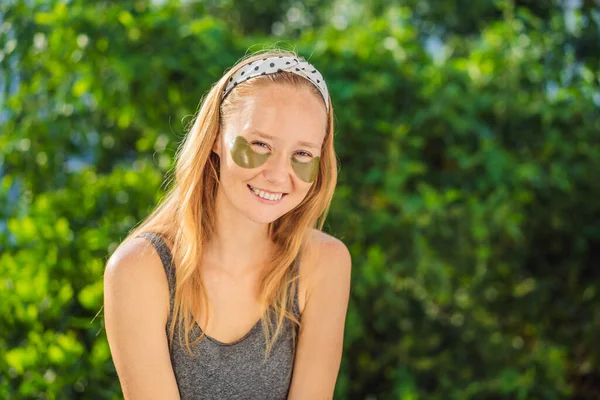 Uśmiechnięta kobieta stosująca plastry do pielęgnacji oczu z hydrożelem, nawilżająca skórę pod oczami, korzystająca z zabiegów pielęgnacji skóry — Zdjęcie stockowe