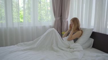 Yataktaki genç bir kadın video konferansında biriyle tartışıyor. Sosyal izolasyon sırasında evde oturmaktan yoruldu.