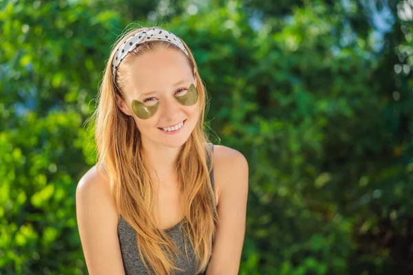 Mujer sonriente aplicando parches hidrogel para el cuidado de los ojos, hidratando la piel debajo de los ojos, disfrutando de procedimientos para el cuidado de la piel —  Fotos de Stock